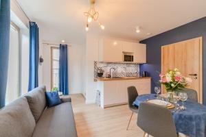 une cuisine et un salon avec une table et des chaises dans l'établissement Apartamenty Pod Orzechem z dużym ogrodem - Dream Apart, à Ustroń