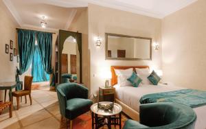 マラケシュにあるRiad El Haraのベッド、椅子、テーブルが備わるホテルルームです。
