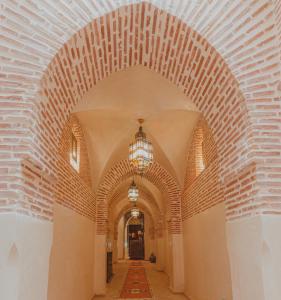 une arche avec un lustre dans un bâtiment dans l'établissement Riad El Hara, à Marrakech