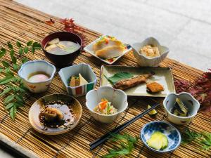 einen Tisch mit Schalen und Teller mit Lebensmitteln in der Unterkunft Kazuraya in Miyoshi