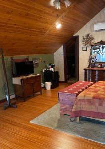 a living room with a bed and a tv at Carriage Stop Bed & Breakfast in Palmyra