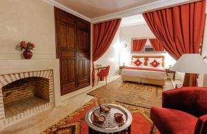 a living room with a bed and a fireplace at Riad El Hara in Marrakech