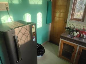 a kitchen with a stainless steel refrigerator in a room at Aashna Castle in Dispur