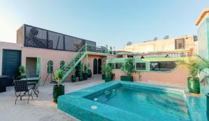 a swimming pool in front of a house at Riad El Hara in Marrakesh