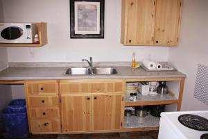 encimera de cocina con fregadero y microondas en Rustico Acres Cottages, en North Rustico