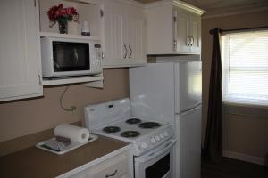 a kitchen with a stove and a white refrigerator at Rustico Acres Cottages in North Rustico