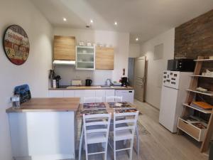 a kitchen with white appliances and a counter with stools at LOT OF BED in Cahors