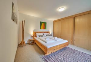 a bedroom with a bed with a wooden headboard at Appartement Mountain & Fun in Saalbach Hinterglemm