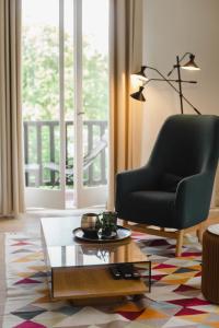 uma sala de estar com uma cadeira e uma mesa de centro em La Villa Normande - Trois Pièces - Deauville Centre em Deauville