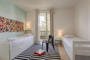 um quarto com 2 camas, uma cadeira e uma janela em La Villa Normande - Trois Pièces - Deauville Centre em Deauville