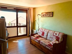 a living room with a couch and a large window at studio cabine Font Romeu in Font Romeu Odeillo Via
