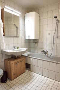 a bathroom with a sink and a tub and a mirror at Apartment im Zentrum von Ried im Innkreis in Ried im Innkreis
