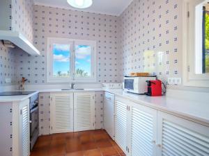 een keuken met witte kasten en een magnetron bij Villa Murada Lisboa by Interhome in Cala Murada