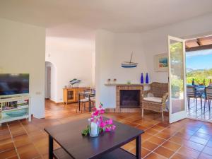 een woonkamer met een tafel en een open haard bij Villa Murada Lisboa by Interhome in Cala Murada