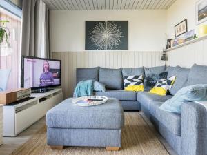 JoutsaにあるHoliday Home Joutsenlampi by Interhomeのリビングルーム(青いソファ、テレビ付)
