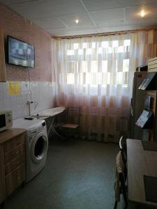 a laundry room with a washing machine and a window at Brīvdienas in Alūksne