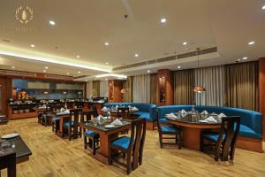 a restaurant with tables and chairs and a bar at Hotel Oil Field in Duliāgaon
