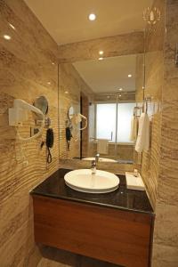 a bathroom with a sink and a large mirror at Hotel Oil Field in Duliajan
