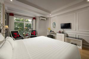1 dormitorio con 1 cama blanca grande y TV en Lavender Central Hotel & Spa Hanoi, en Hanói