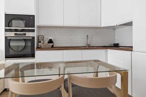 a kitchen with a glass table and two chairs at Timeless Sea II Apartment in Armação de Pêra +13 photos