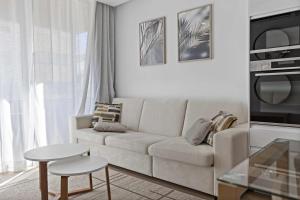 a white living room with a couch and a table at Timeless Sea II Apartment in Armação de Pêra