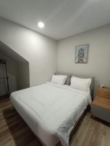 a bedroom with a large white bed with white pillows at HOM Penuin Batam in Nagoya
