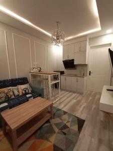 a living room with a couch and a kitchen at HOM Penuin Batam in Nagoya