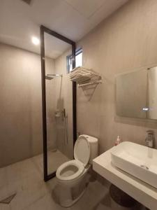 a bathroom with a toilet and a sink at HOM Penuin Batam in Nagoya