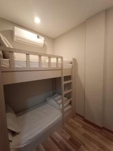a small room with bunk beds with a fan at HOM Penuin Batam in Nagoya