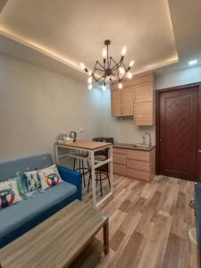 a living room with a blue couch and a kitchen at HOM Penuin Batam in Nagoya