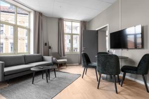 a living room with a couch and a table and chairs at Forenom Serviced Apartments Drammen in Drammen