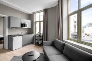 a living room with a couch and a kitchen at Forenom Serviced Apartments Drammen in Drammen