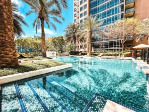 a large swimming pool with palm trees and buildings at Elite Royal Apartment - Panoramic Full Burj Khalifa, Fountain & Skyline view - Baron in Dubai