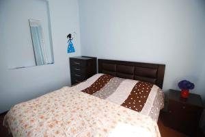 a bedroom with a bed with a quilt and a dresser at Mshvidoba in Ushguli