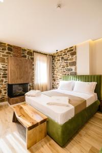 a bedroom with a large bed and a fireplace at Vecchia Boutique Hotel in Korçë