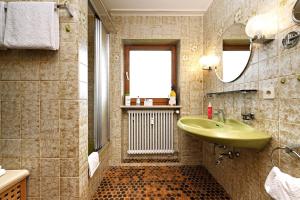 ein Badezimmer mit einem grünen Waschbecken und einem Spiegel in der Unterkunft Ferienwohnung Karin in Bolsterlang