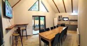 - une salle à manger et une cuisine avec une table et des chaises en bois dans l'établissement Casa Justin, à Gura Humorului