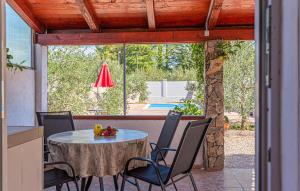 une terrasse avec une table, des chaises et une piscine dans l'établissement Cozy Home In Bilice With Kitchen, à Bilice