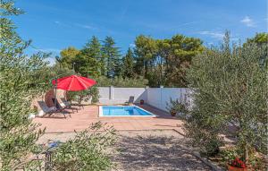 a patio with a pool and a red umbrella at Cozy Home In Bilice With Kitchen in Bilice