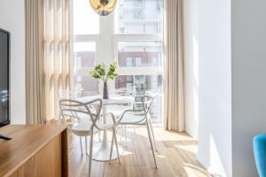 a dining room with a table and chairs and a window at Sunlit 1 Bedroom Apt in Porta Nuova in Milan