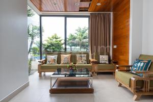 ein Wohnzimmer mit Sofas und einem Tisch in der Unterkunft Cozrum Luxury - Aria Resort Vũng Tàu in Xã Thắng Nhứt