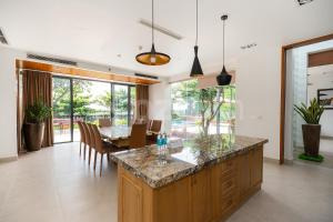 a kitchen and dining room with a table and chairs at Cozrum Luxury - Aria Resort Vũng Tàu in Xa Thang Nhut