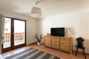 a living room with a flat screen tv on a wooden dresser at Holiday Home Julia in Valdaora