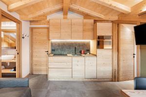 a kitchen with wooden walls and wooden ceilings at Aria di Casa Reit in Valdisotto