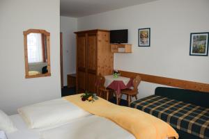 a room with two beds and a table and a mirror at Hochkarhof in Göstling an der Ybbs