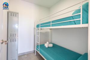 1 dormitorio con 2 literas con sábanas azules en Apartamentos Arcos I Casa Azahar, en Alcossebre