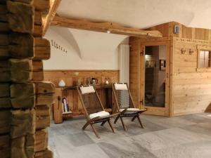 two chairs in a room with a stone wall at La Fattoria di Roven in Gignod