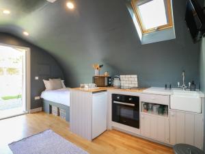 um quarto com uma cama e uma cozinha com um lavatório em Oak em Uttoxeter