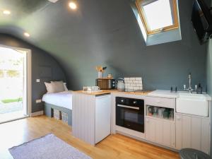 a room with a bed and a kitchen with a sink at Oak in Uttoxeter