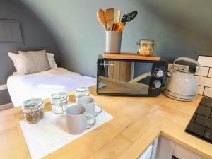 um balcão de cozinha com duas chávenas e um micro-ondas em Oak em Uttoxeter